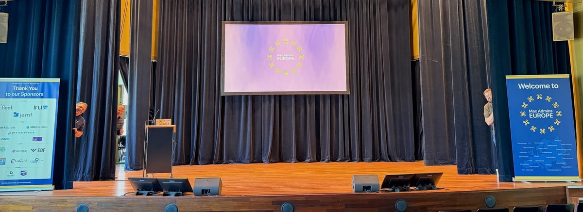 The Mac Admins Europe Stage with some people peeking in from the wings.